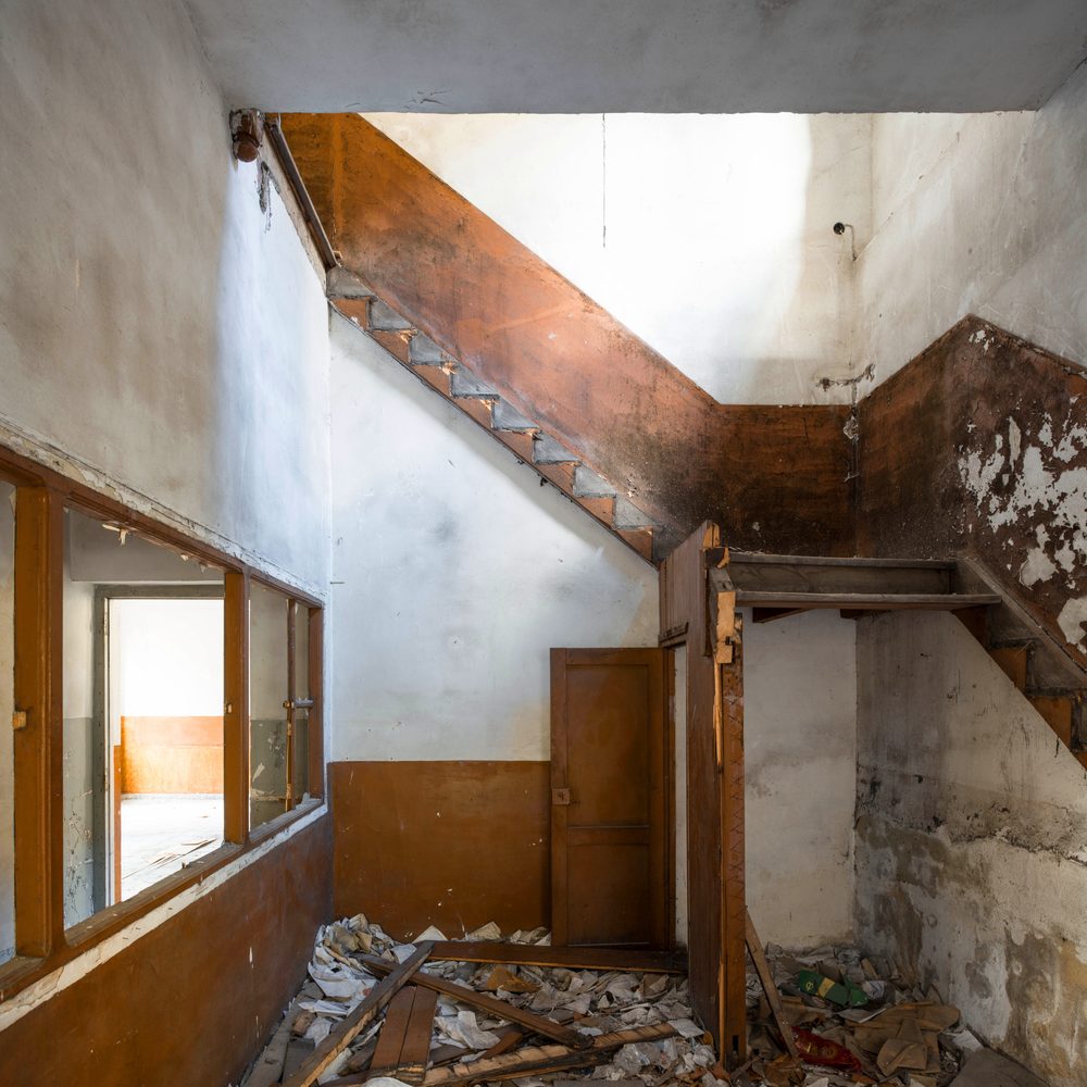 Vecchio controsoffitto smontato rivela la struttura nascosta del soffitto di una casa storica.